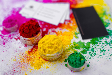 indian holi festival concept, holi colors and credit card or visiting card on white background
