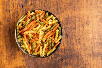 Three colors fusilli pasta. Colorful italian raw pasta in bowl.