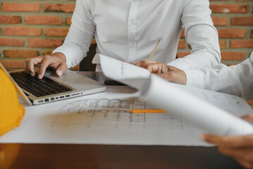 Working as a team architect and designer working on blueprint project of new apartments. Photo concept of work on technical drawings in office.
