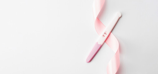 Pregnancy test isolated. Positive woman pregnant test with pink silk ribbon on white background. Medical healthcare gynecological, pregnancy fertility maternity people concept.
