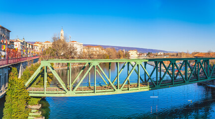 View of an old iron railway bridge over the Dora Baltea river, in the city of Ivrea (Torino province,  Piedmont, Northern Italy); world famous for its carnival, is UNESCO Site since 2018.