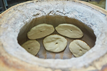 Making and baking bread in tandoor. The national way of food recipes. Production of bakery products...