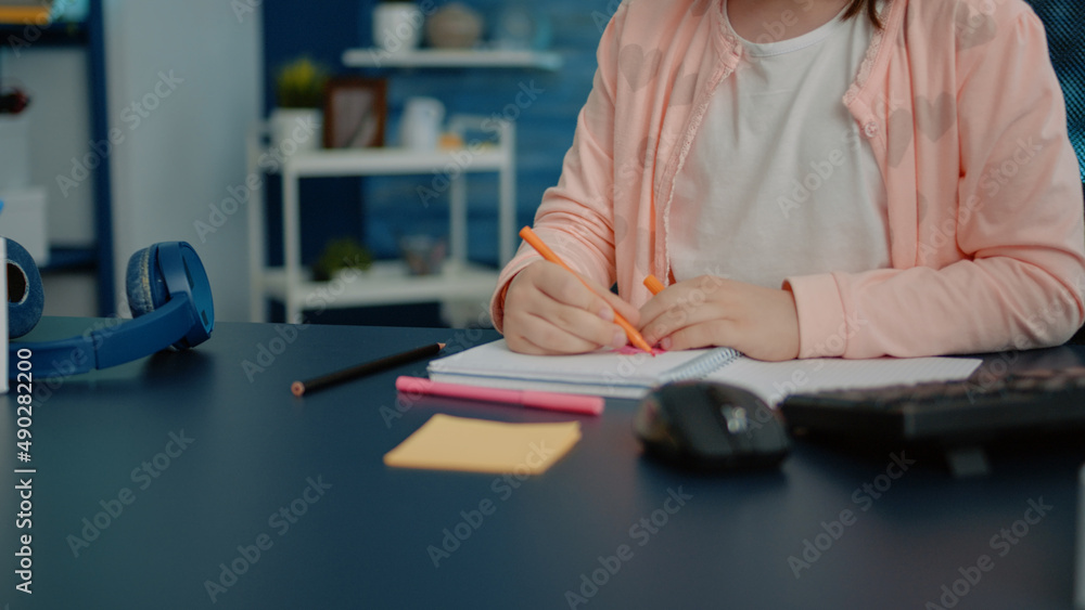 Aufkleber close up of hands of child using pencils for colorful notebook at desk with computer, keyboard and t