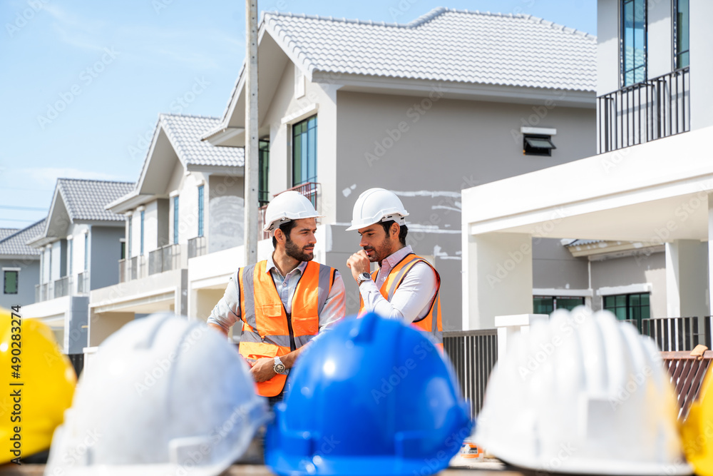Aufkleber professional architects in safety vests at a construction site while discussing their work plan at b