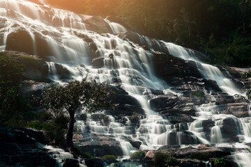 waterfall in the mountains with evening light. 