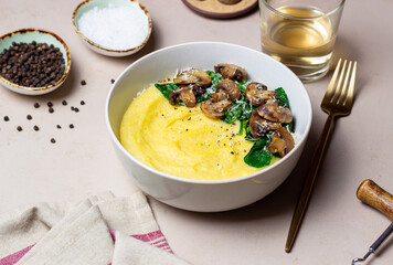 Polenta with mushrooms, spinach and cheese. Healthy eating. Vegetarian food. Italian cuisine.