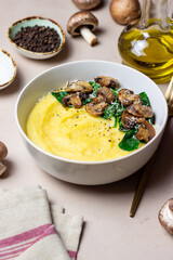 Polenta with mushrooms, spinach and cheese. Healthy eating. Vegetarian food. Italian cuisine.