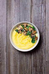 Polenta with mushrooms, spinach and cheese. Healthy eating. Vegetarian food. Italian cuisine.