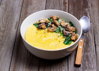 Polenta with mushrooms, spinach and cheese. Healthy eating. Vegetarian food. Italian cuisine.