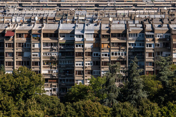 Row of apartment buildings in residential quarter of Belgrade city, behind the treetops. Multistory apartment complex at urban area.