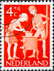 Netherlands - circa 1962: a postage stamp from the Netherlands, showing children cooking at a...