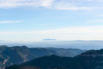Mountains landscape with the Montserrat massif on the horizon above the clouds