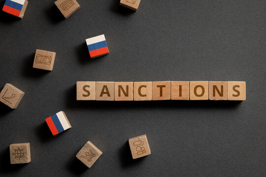 Wooden cubes with financial icons, Russian flag and sanctions. Concept on sanctions in Russia