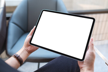 Fototapeta Mockup image of a woman holding digital tablet with blank white desktop screen in cafe obraz