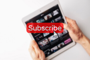 Subscription plan. Red online video subscribe button. Internet service on laptop digital tablet blured technology background. Visual contents concept. Social networking service.