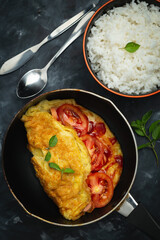 Breakfast tomato omelette on dark background