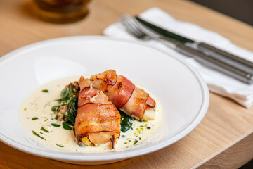 fried bacon rolls with sauce and herbs