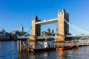 Foto auf Leinwand Tower Bridge with a red bus crossing on a sunny day with blue sky © Edward
