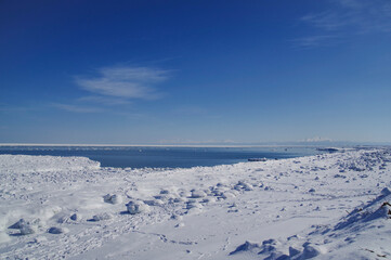 Fototapeta na wymiar 海岸から見る流氷が浮かぶオホーツク海と知床連峰