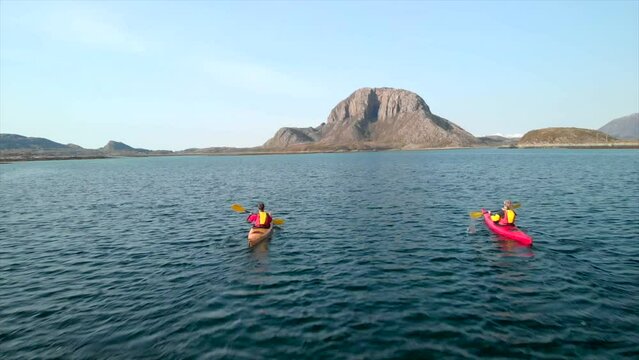 Aerial drone push in 4k shot over kayakers headed towards amazing Torghatten mountain in helgeland, Norway