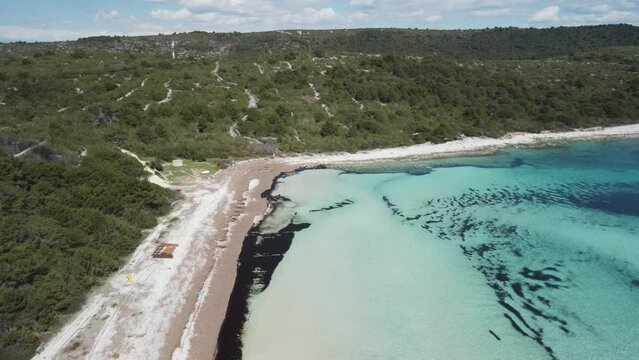 Empty sandy beach with the crystal blue Mediterranean sea  in the summer, 4K drone footage in Dugi otok, Croatia