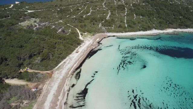 Sandy beach without people with the crystal blue Mediterranean sea in the summer, 4K drone footage in Dugi otok, Croatia