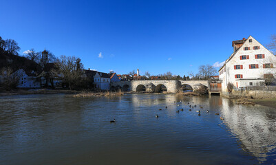 Fototapeta na wymiar Blick über die historische Steinbrücke über den Fluss Wörnitz in Harburg in Schwaben, bei strahlend blauem Himmel im Winter. Bayern, Deutschland, 