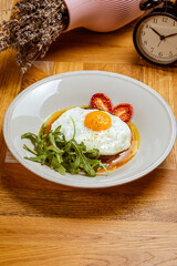 breakfast fried eggs with beefsteak, arugula and sun-dried tomato