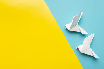 Two white birds as a symbol of peace on on blue and yellow pastel paper color for background