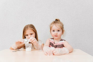 cute little girls in protective gloves conduct an experiments at home 