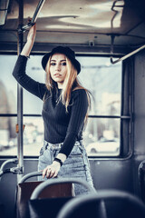 girl in a hat rides on a public tram