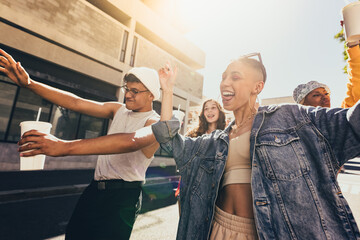 Young friends dancing cheerfully in the city