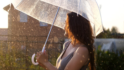 Happy young woman dancing and having fun with umbrella outdoor at sunny weather
