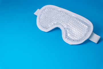 White mask with transparent gel balls inside for hot and cold aesthetic treatment on blue background. Anti-wrinkle and anti-aging treatment. horizontal photography with copyspace