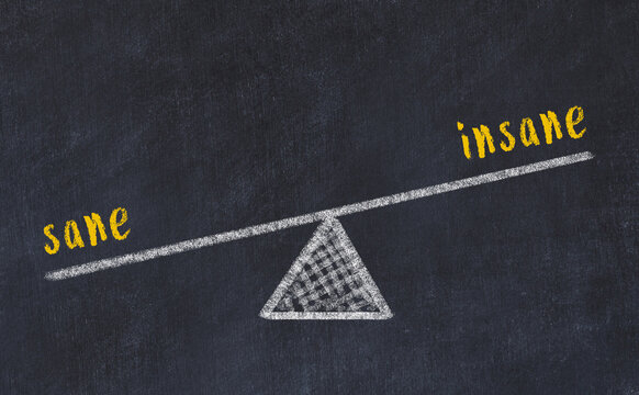 Concept of balance between sane and insane. Chalk scales and words on it