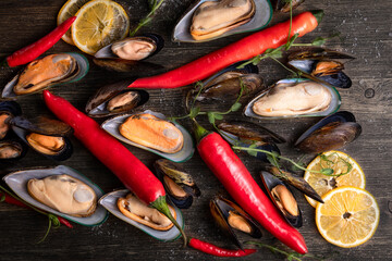cooked mussels on a wooden background, the background is decorated with greens, pepper, microgreens, salt