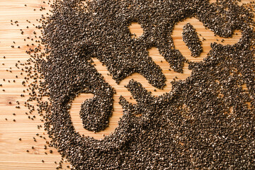 Chia seeds with text isolated on wooden background top view
