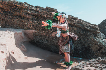 Hawaiian woman enjoys hula dancing on the beach barefoot wearing traditional costume