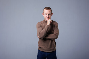 Fototapeta premium Portrait of a cheerful young handsome man, male, isolated gray wall background. Positive human emotions, facial expressions. Advertising concept, customer satisfaction