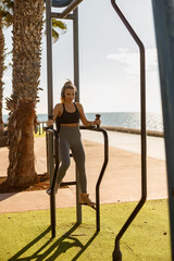 Young fitness woman doing exercises in park