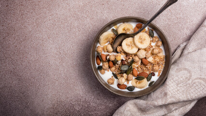 Healthy breakfast of granola with nuts, banana and yogurt