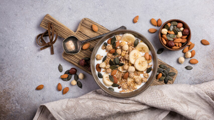 Healthy breakfast of granola with nuts, banana and yogurt