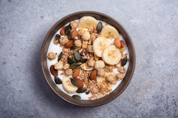 Healthy breakfast of granola with nuts, banana and yogurt
