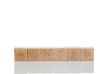 Wooden cubes with letters wonder on a white background