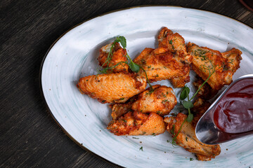 fried chicken wings served with beer on a dark background