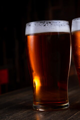 a glass of foamy beer on a dark background