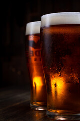a glass of foamy beer on a dark background