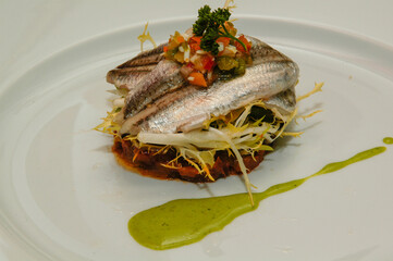 Anchoas marinadas sobre ensalada casera.