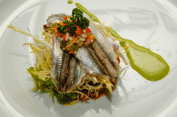 Anchoas marinadas sobre ensalada casera.