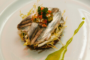 Anchoas marinadas sobre ensalada casera.
